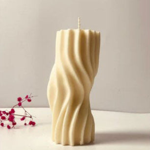 Wavy-textured candle on table