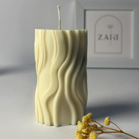 Wave-patterned aesthetic candle on a gray surface