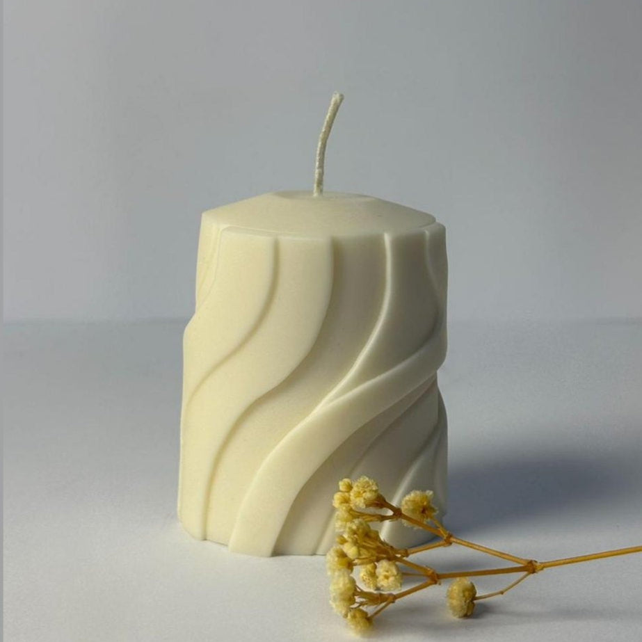 Hexagonal candle with wavy pattern on a gray background