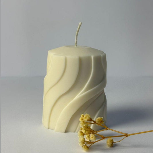 Hexagonal candle with wavy pattern on a gray background